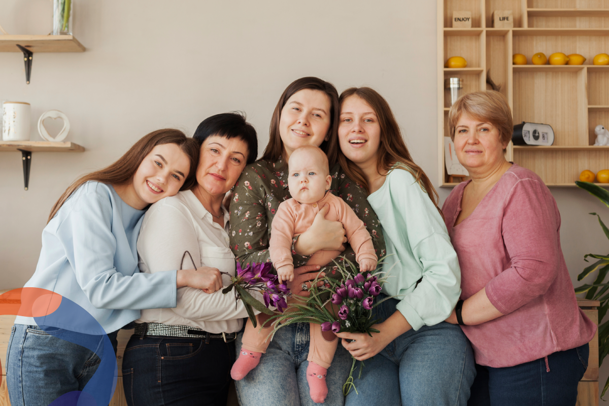 Grupo de mujeres de diferentes edades abrazándose y sonriendo, simbolizando la unión y el empoderamiento femenino.